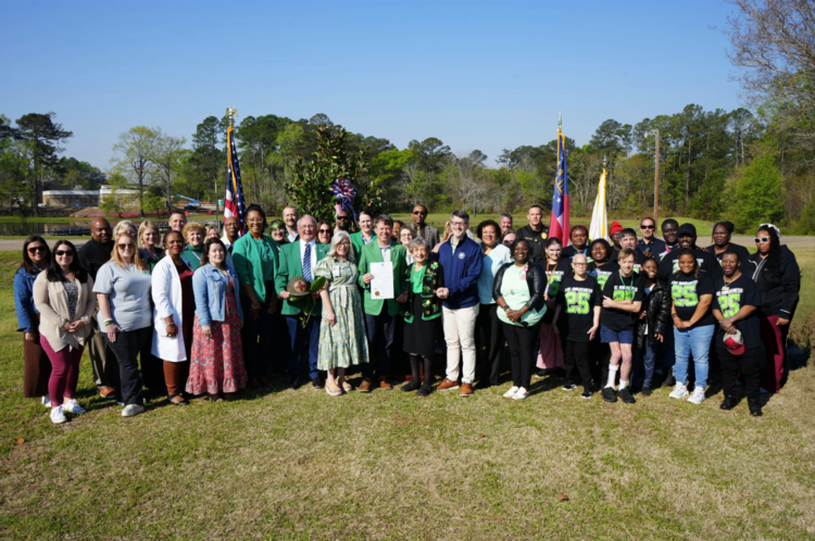 Group of people standing around a newly planted tree